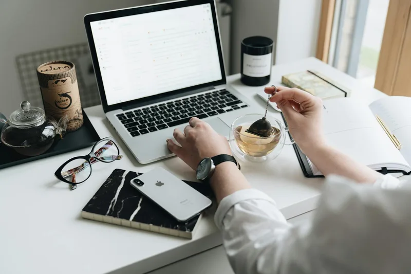 A cozy home office workspace with a laptop and tea, the setup where most solo creators write their launch emails