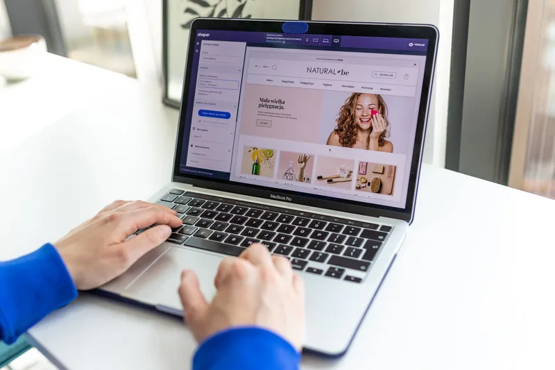 Hands typing on a laptop with a course sales page open, showing product details and a call to action button