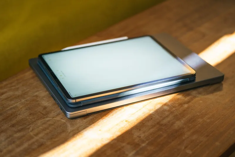 Modern workspace with tablet and laptop showing digital product files ready for download