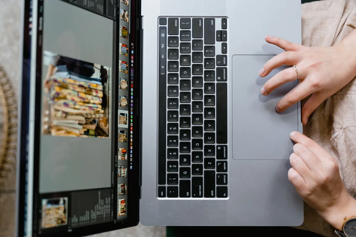 Solo creator editing files on a laptop preparing digital products for sale