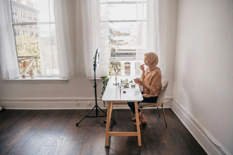Woman content creator working at a desk in natural light, creating digital content