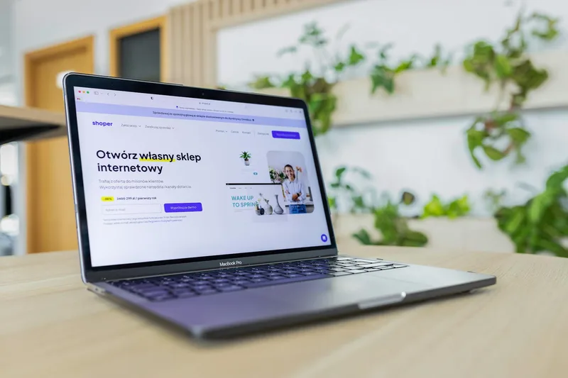 E-commerce website on a laptop screen surrounded by modern office decor