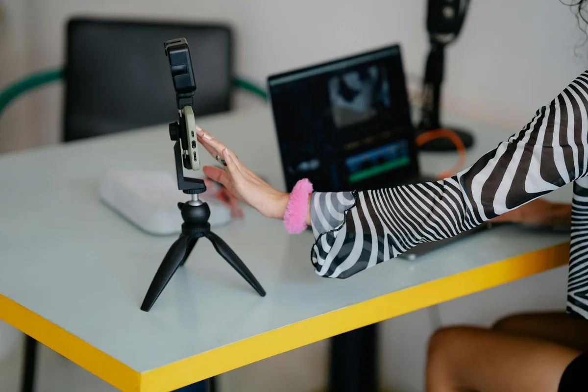 Creator at a desk recording a video against a clean background representing a video sales letter setup for solo entrepreneurs