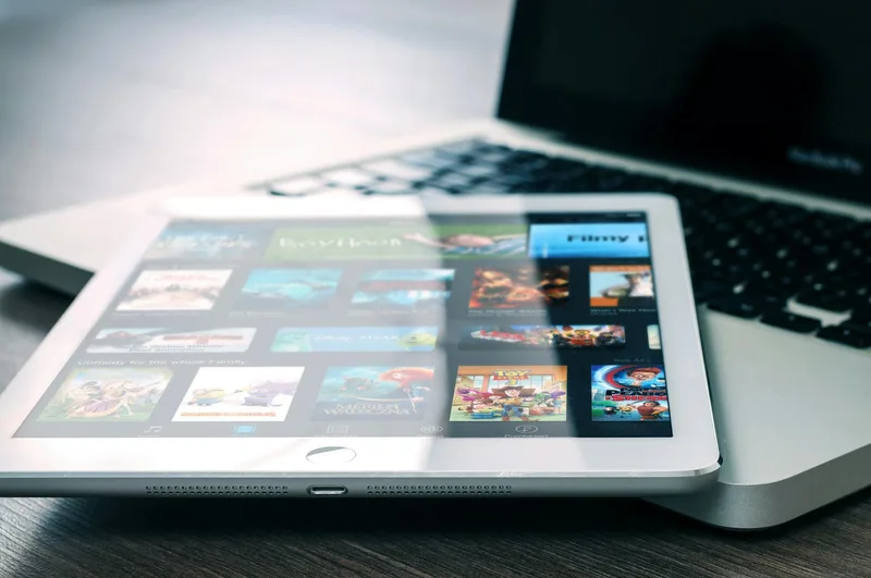 Laptop showing a video player interface on a landing page with a visible call-to-action button below it