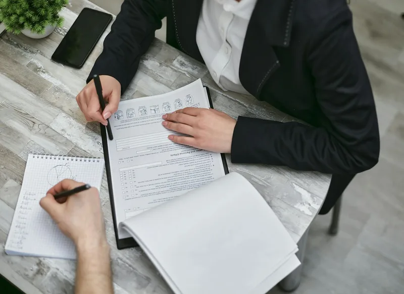Person at a desk reviewing a checklist representing the tools and setup needed to launch a VSL funnel as a solo creator