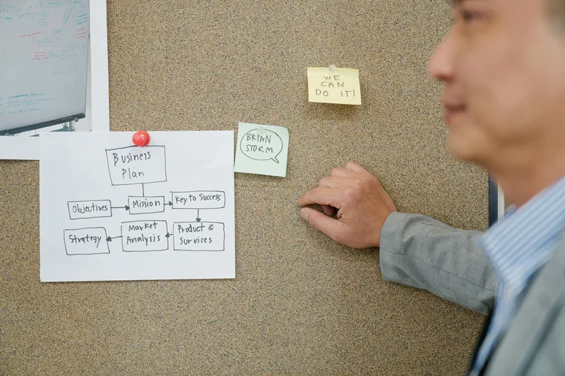 Business notes organized on a corkboard, representing the planning process of choosing the right email platform for a creator funnel