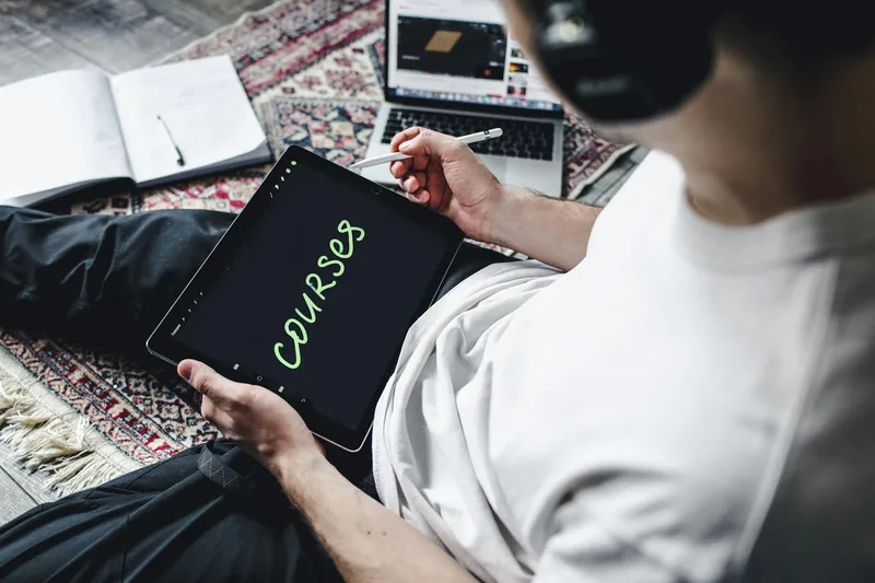 Person studying an online course on a digital tablet with headphones