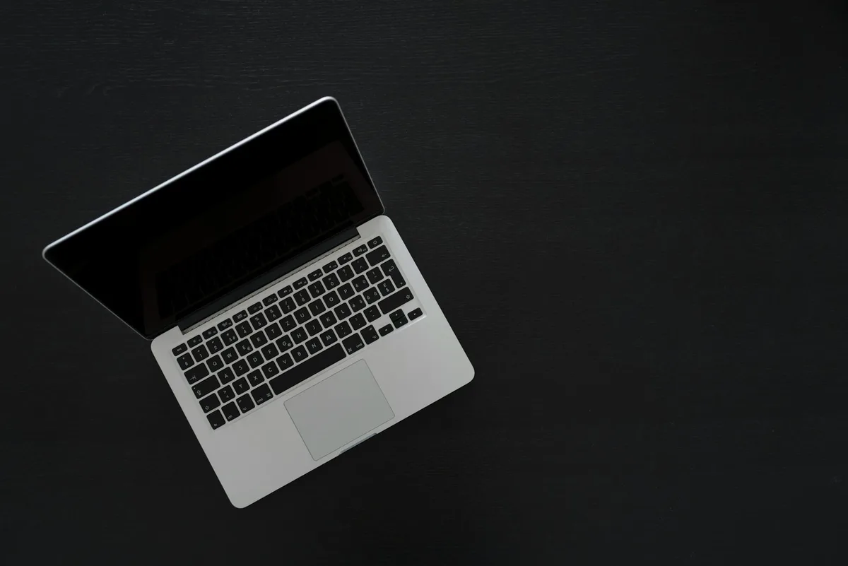 Overhead view of a MacBook laptop on a dark minimal desk
