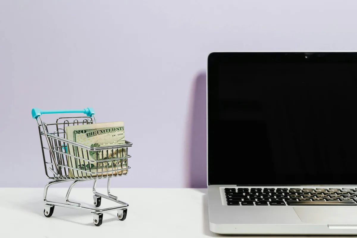 Online shopping cart and laptop representing sales funnel and e-commerce setup for solo creators