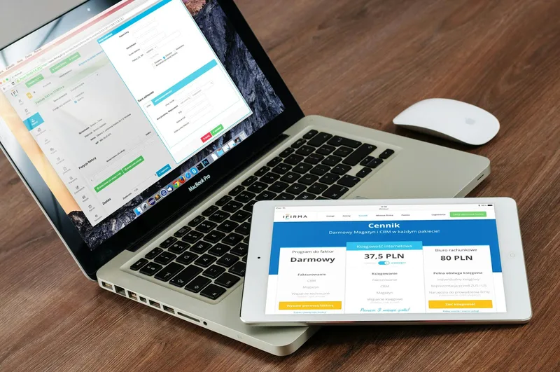Laptop and tablet side by side on a desk, representing the comparison of multiple software tools for solo creators